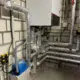 Wandhängendes Gas-Brennwertgerät Vitodens 200-W nach Heizungsmodernisierung in Schifferstadt, darunter gedämmte Heizungsrohre und blaue Kondensathebeanlage